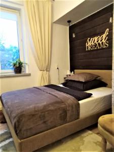 Un dormitorio con una cama grande con un cartel. en Wygodny Apartament w Śródmieściu Gdańska, en Gdansk