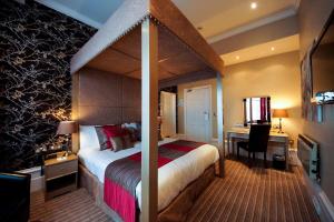 a hotel room with a bed and a desk and a bed sidx sidx sidx sidx at Best Western York House Hotel in Eastbourne