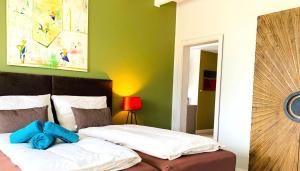 um quarto com uma cama e uma parede verde em BESOTEL Mettmann em Mettmann