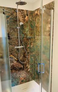 uma casa de banho com um chuveiro e uma porta de vidro em BESOTEL Mettmann em Mettmann
