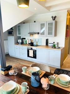 uma cozinha com armários brancos e uma mesa de madeira em BESOTEL Mettmann em Mettmann