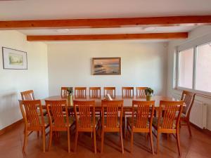 uma sala de jantar com uma mesa de madeira e cadeiras em Zöldpart Villa em Balatonszárszó