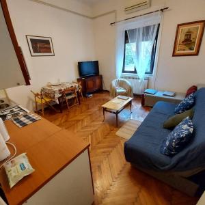 ein Wohnzimmer mit einem blauen Sofa und einem Tisch in der Unterkunft Relax inn Condominium-Zagreb in Zagreb