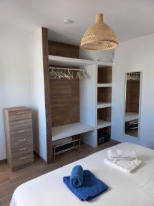 a bedroom with a bed with a blue towel on it at Apartamento recien reformado en centro a tres minutos de la playa in Corralejo