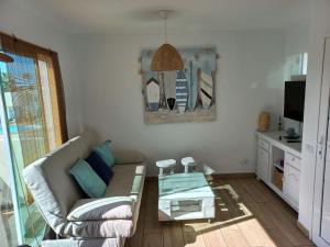 a living room with a couch and a glass coffee table at Apartamento recien reformado en centro a tres minutos de la playa in Corralejo
