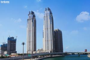 un groupe de grands bâtiments dans une ville avec un pont dans l'établissement bnbmehomes - Lux 2B Apt - Dubai Canal Water View - 4406, à Dubaï