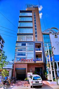 un edificio con un'auto parcheggiata di fronte di Royal Pearl Hotel a Mandalay