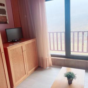 a living room with a tv and a large window at FB 58 Confort in Pas de la Casa