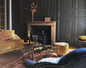 sala de estar con sofá, mesas y chimenea en Ancienne Perception, en Boussac