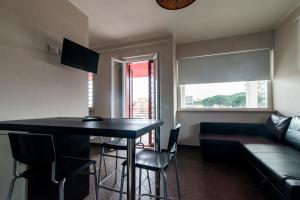 uma sala de estar com uma mesa e cadeiras e um sofá em Guest House Roma Express em Ladispoli