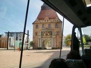 een groep mensen in een bus voor een gebouw bij Ferienwohnungen Am Schwanenteich in Rostock