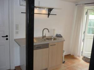 a kitchen with a sink and a counter at Little Rose Cottage - Urlaub unter Reet zwischen den Meeren in Börm