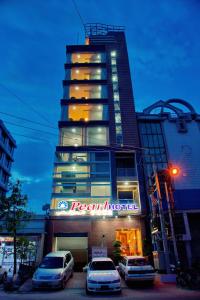 un hotel con coches estacionados frente a un edificio en Royal Pearl Hotel, en Mandalay