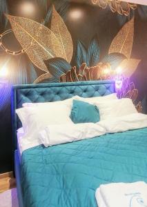 1 dormitorio con cama azul y almohadas blancas en Apartman Morska Pahulja Zlatibor i spa centar, en Zlatibor
