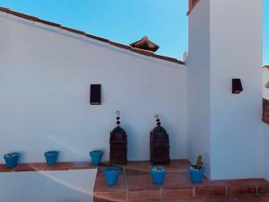 Habitación con macetas azules y pared blanca en casita valdivia, en Gaucín