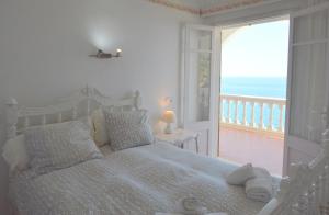 ein Schlafzimmer mit einem Bett mit Blick auf das Meer in der Unterkunft Alconasser 10 - Amazing Seaviews between Deia & Soller in Port de Sóller