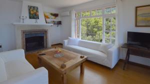 ein Wohnzimmer mit einer weißen Couch und einem Kamin in der Unterkunft Alconasser 10 - Amazing Seaviews between Deia & Soller in Port de Sóller