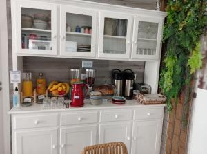 a kitchen with white cabinets and a counter at Nazaré Sweet Dreams in Nazaré