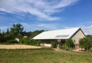 a large white barn with a white roof at Emma in Burladingen