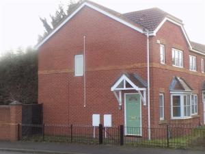una casa de ladrillo rojo con una puerta verde en Hive Close, en Stockton-on-Tees