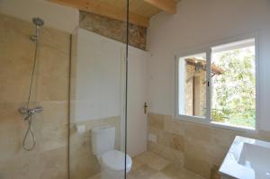 a bathroom with a shower and a toilet and a window at Alconasser 2 - Amazing Seaviews between Deia & Soller in Sóller +15 photos