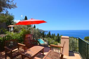 a patio with a table and a red umbrella at Alconasser 2 - Amazing Seaviews between Deia & Soller in Sóller
