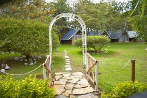 um arco sobre um caminho de pedra num jardim em Camp Mahon Gardens em Nanyuki