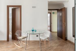 una mesa de cristal y sillas en una habitación en Flaminiarooms, en Roma