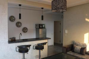 uma cozinha com um bar e um sofá num quarto em Tiwaline Tarsime App E em Sidi Ifni