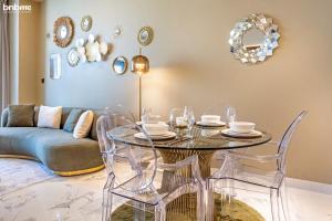 una sala da pranzo con tavolo, sedie e divano di bnbmehomes - Luxury 2B Apt - Al Habtoor - Amna Tower - 4405 a Dubai