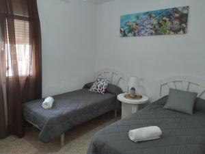 a bedroom with two beds and a table and a picture at Villapreciosa in Peñíscola +101 photos