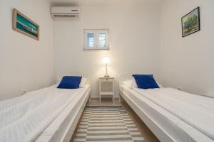two beds with blue pillows in a room at Villa Tatijana ZadarVillas in Kukljica +60 photos
