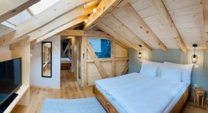 a bedroom with a large bed in a room with wooden ceilings at Chalet Bergheimat Zermatt in Zermatt
