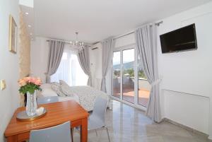 Villa Antea Apartments في دوبروفنيك: غرفة معيشة مع طاولة وأريكة وتلفزيون