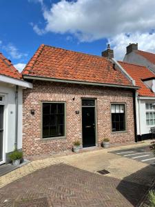 une maison en briques avec un toit orange dans l'établissement Huisje Harderwijk, à Harderwijk