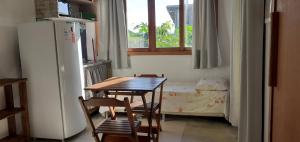 a kitchen with a table and chairs and a table and a window at Pousada Praia Verde in Imbituba