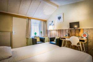 Cette chambre comprend un lit, un bureau et des chaises. dans l'établissement Carré Hotel Zuid-Limburg, à Hulsberg