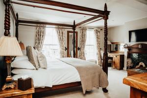ein Schlafzimmer mit Himmelbett und Kamin in der Unterkunft The Peppermill Boutique Hotel in Devizes