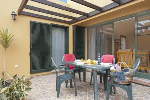 un patio con mesa y sillas en La Casa del Sol l by Best Holidays Fuerteventura, en Corralejo