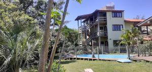 a house with a swimming pool next to a building at Pousada Praia Verde in Imbituba