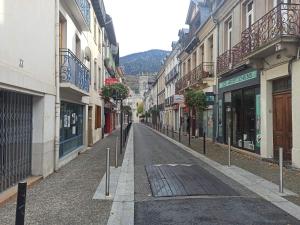an empty street in a city with buildings at Le Therminus, T2Bis au cœur de Luchon in Luchon