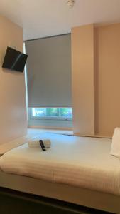 a large bed in a room with a window at easyHotel Victoria in London