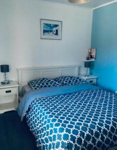 a blue bedroom with a bed and two night stands at Charmante maison de village à 50m de la plage in Excénevex