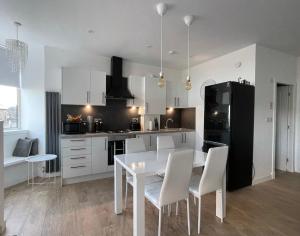 a kitchen with a white table and white chairs at Dunoon River Clyde Flat in Innellan
