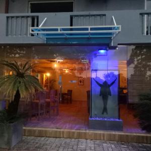 a reflection of a man in a window at night at This Is It Airport Hotel and Restaurant in Negombo