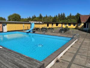 a swimming pool with a slide and a playground at Bygholm Camping og aktiviteter in Vesløs