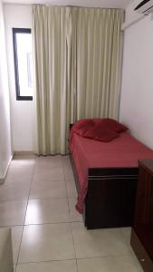 ヴィラ・カルロス・パスにあるDepartamento Sorrentosのベッドルーム1室(赤いベッド1台、窓付)
