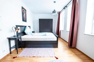 a bedroom with a bed and a table and a window at Mein Brühl-Stadtmitte, fußläufig zur TU und Bibliothek in Chemnitz