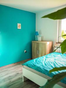 um quarto azul com uma cama e um armário de madeira em Domek w Górach na wyłączność em Złatna