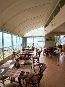 ein Restaurant mit Tischen und Stühlen und Meerblick in der Unterkunft Praia Pousada Tatuíra in Florianópolis